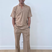 Dune caramel two-piece set featuring a short-sleeved V-neck tunic and matching straight-leg trousers with a sharp front crease. -Front View