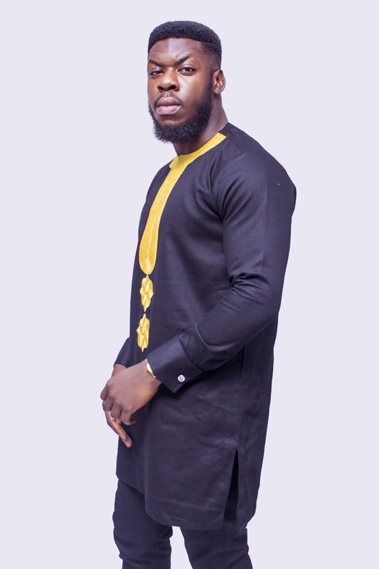 African Suit featuring a longline black tunic with a gold embroidered round neckline, a central embroidered vertical panel, two matching gold geometric chest medallions, and coordinating tailored trousers