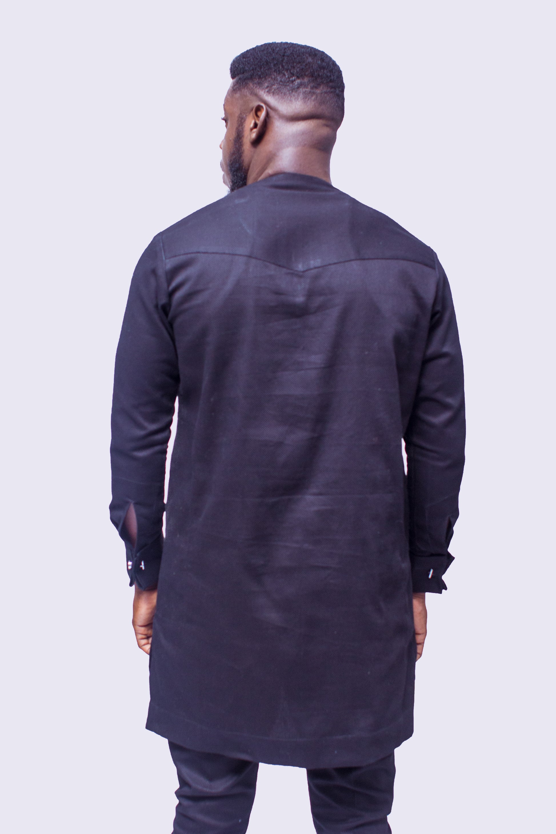 African Suit featuring a longline black tunic with a gold embroidered round neckline, a central embroidered vertical panel, two matching gold geometric chest medallions, and coordinating tailored trousers