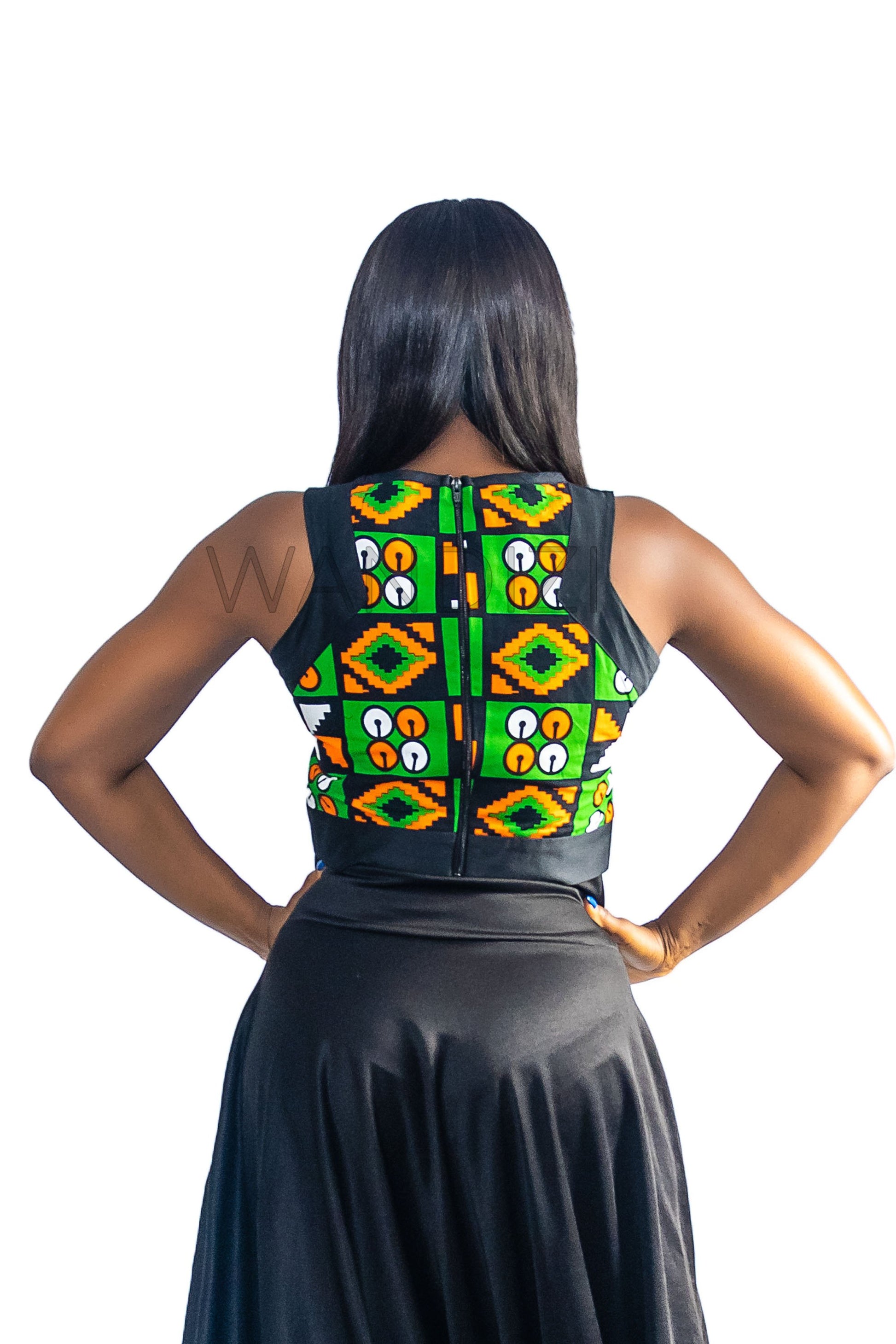 Ankara Top featuring a sleeveless, high-neck crop silhouette with a vibrant green, orange, and yellow geometric print paneled with broad black structural borders