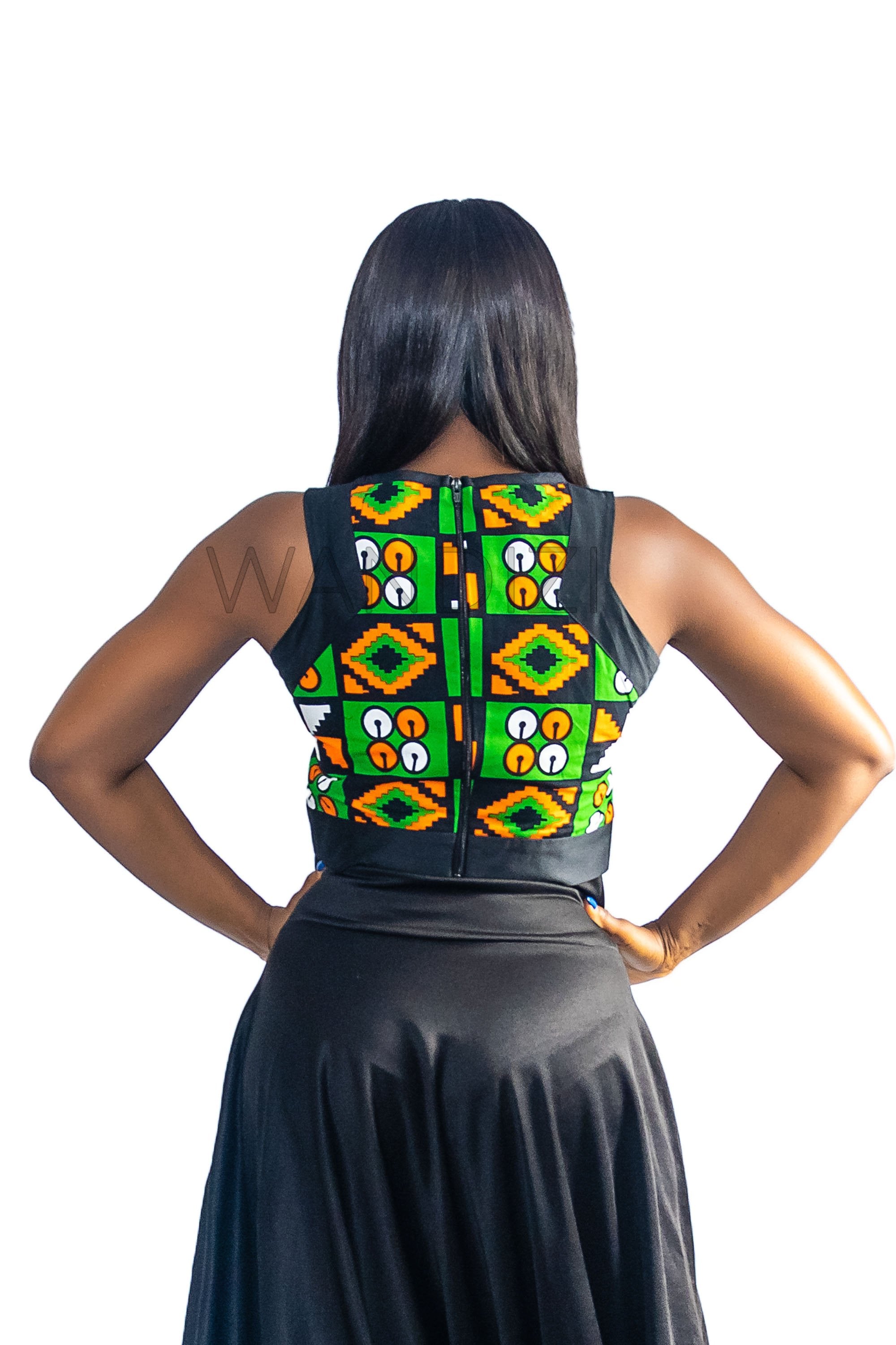 Ankara Top featuring a sleeveless, high-neck crop silhouette with a vibrant green, orange, and yellow geometric print paneled with broad black structural borders