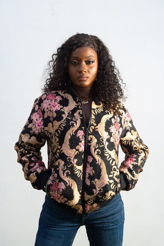 Gilded Rose Floral Bomber Jacket  featuring a black velvet-texture fabric with intricate pink rose and gold scrollwork patterns. Front View