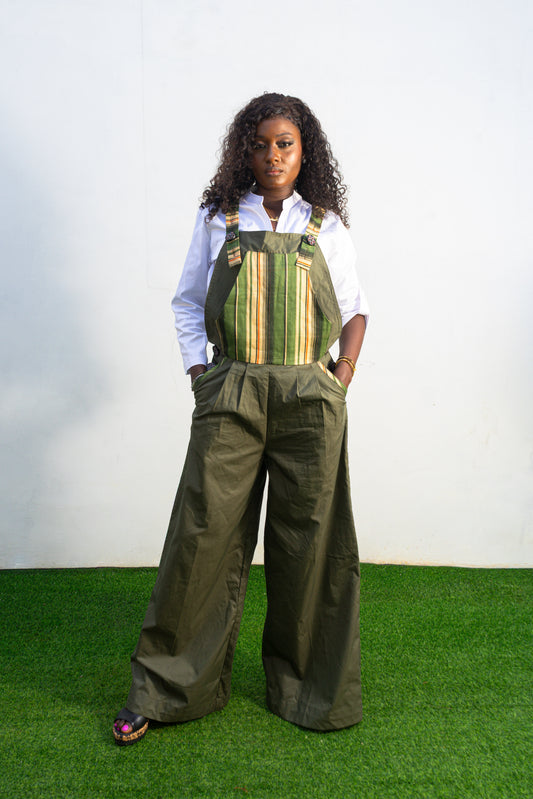 Verdant Patchwork Cotton Jumpsuit featuring wide-leg olive trousers and a bib panel with green, black, and orange vertical stripes. 
