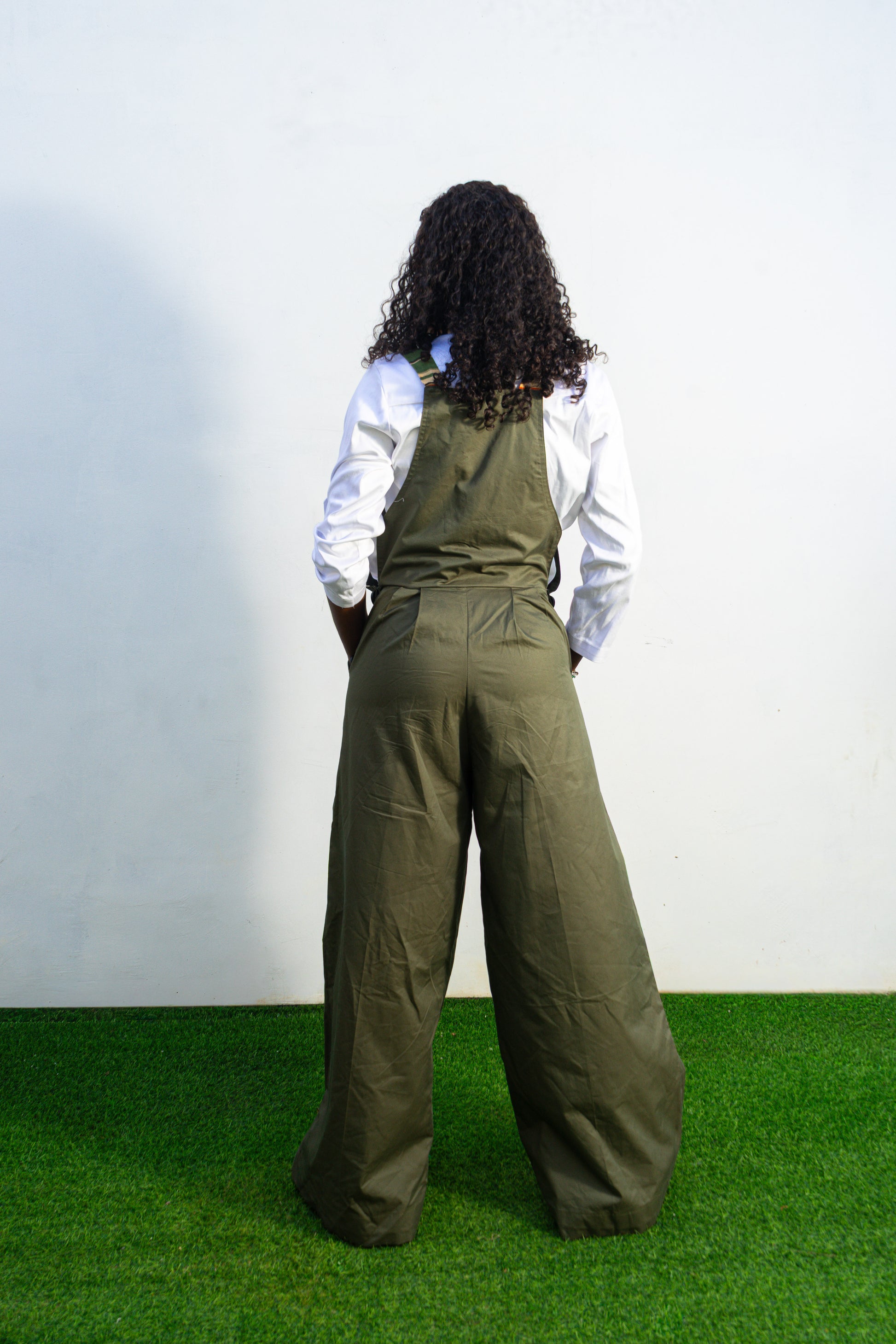 Verdant Patchwork Cotton Jumpsuit featuring wide-leg olive trousers and a bib panel with green, black, and orange vertical stripes. Back View