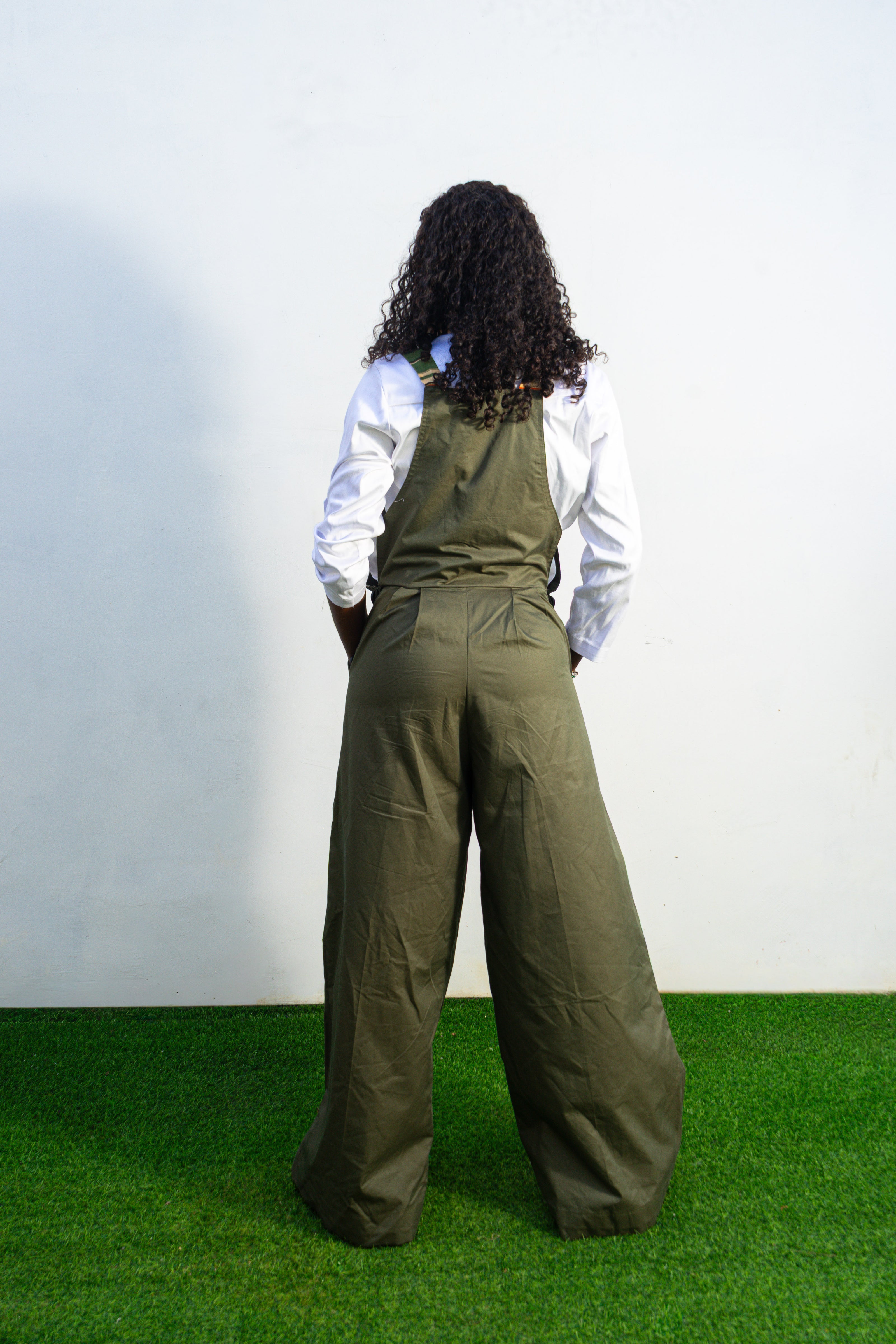 Verdant Patchwork Cotton Jumpsuit featuring wide-leg olive trousers and a bib panel with green, black, and orange vertical stripes. Back View