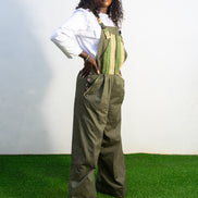 Verdant Patchwork Cotton Jumpsuit featuring wide-leg olive trousers and a bib panel with green, black, and orange vertical stripes. Side View