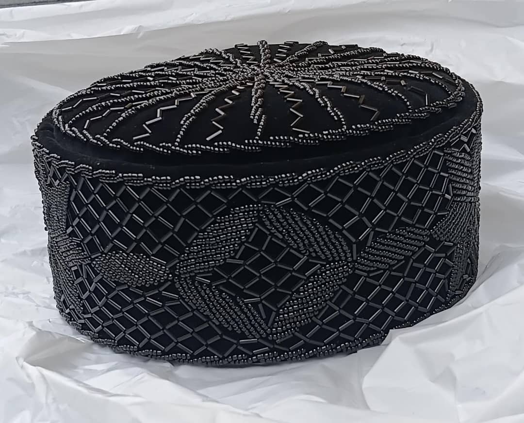 Crown Cap featuring rich black velvet adorned with intricate, hand-stitched black beadwork in starburst and geometric lattice patterns.