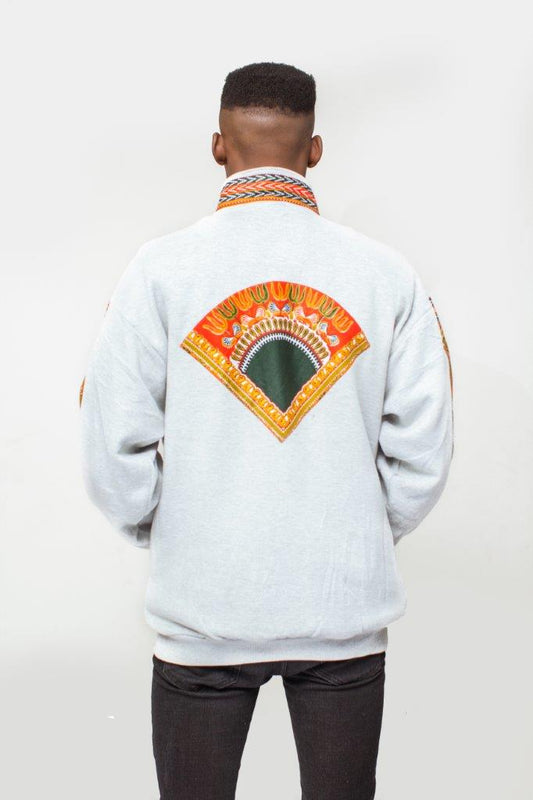 Dashiki Bomber Jacket featuring a light grey body with a striking orange, yellow, and green traditional African print on the high collar, chest panel, front pouch pocket, and sleeve borders