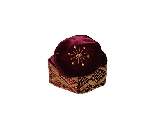 Fila Cap featuring burgundy velvet with a gold starburst on the crown and a geometric lattice embroidery pattern around the base.
