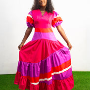 Magenta Sunset Full length Dress featuring a V-neckline, short puff sleeves, and tiered color-block panels in magenta, purple, and orange. Front View