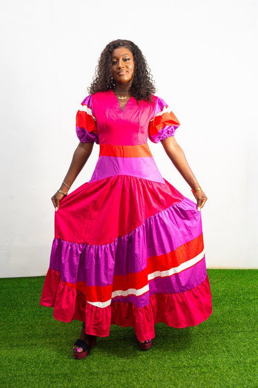 Magenta Sunset Full length Dress featuring a V-neckline, short puff sleeves, and tiered color-block panels in magenta, purple, and orange. Front View