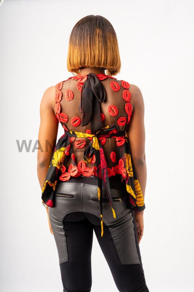 Handkerchief Top featuring a sheer mesh upper bodice adorned with textured red lace floral details, transitioning into a flared, asymmetrical black Ankara printed peplum with bold yellow and red patterns
