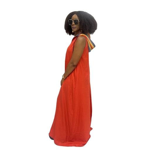 Sleeveless orange maxi dress featuring a hooded neckline with multicolor pattern lining, front zip detail, and a voluminous floor-length skirt.