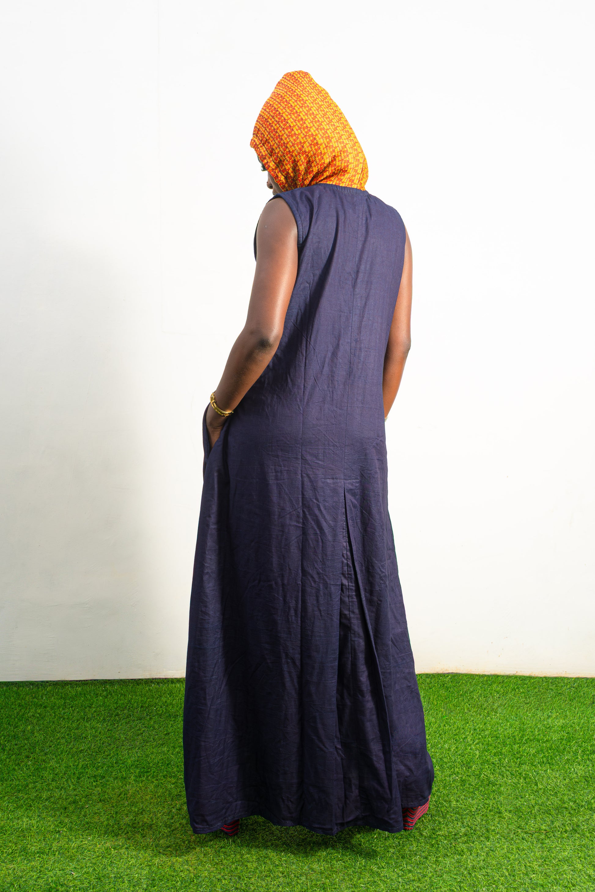 Orange and black Diamond Patterned Jumpsuit featuring a sleeveless black frame with large orange diamond-shaped patchwork across the front and an attached hood. Back View