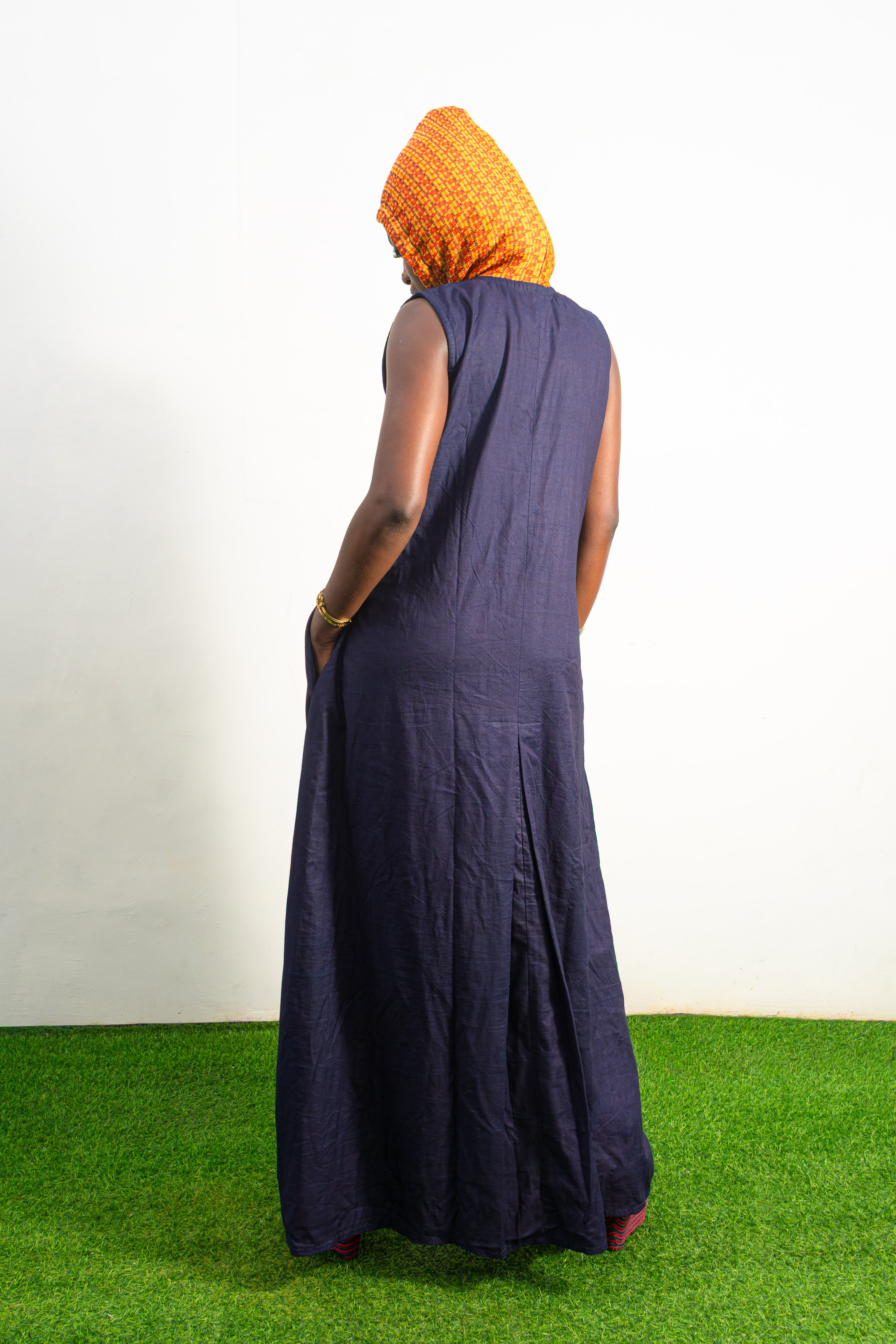 Orange and black Diamond Patterned Jumpsuit featuring a sleeveless black frame with large orange diamond-shaped patchwork across the front and an attached hood. Back View