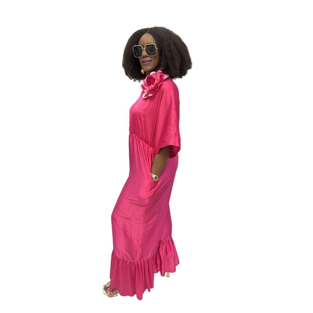 Magenta Jumpsuit featuring a one-shoulder neckline with a large pink floral detail, an elasticated waist, and wide-leg trousers with ruffled hems.