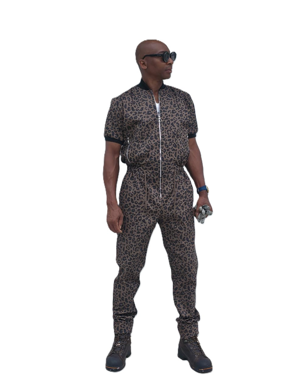 Short-sleeved jumpsuit featuring a brown and black animal print, a silver front zipper, and black ribbed cuffs