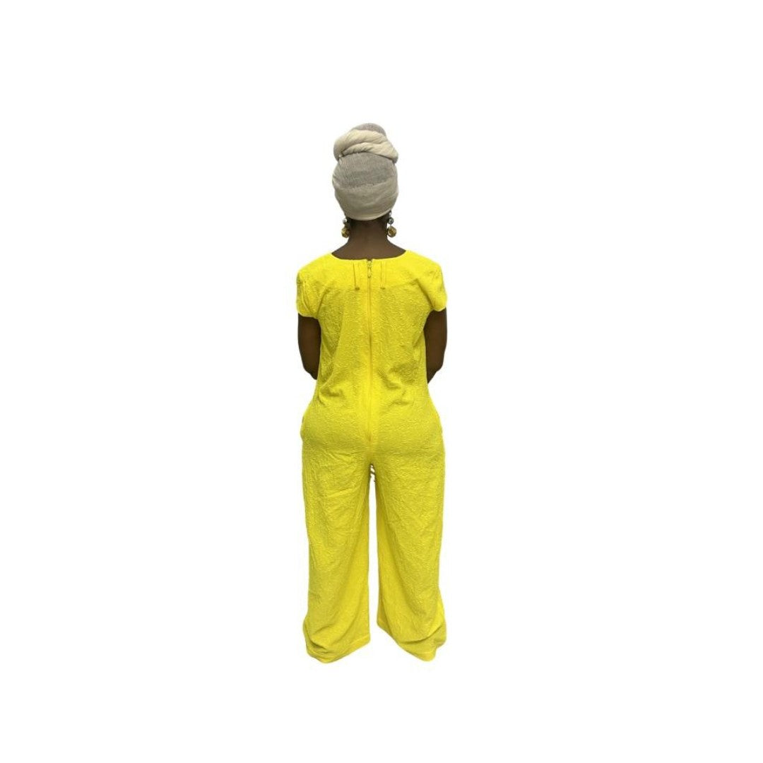 Jumpsuit featuring a sleeveless V-neckline, a prominent matching yellow neck tie, and long wide-leg trousers