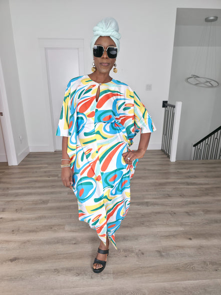 Abstract Aurora Boubou Kaftan featuring a colorful turquoise, orange, and yellow swirl pattern on white silk-satin with a mint headwrap. Front Pose