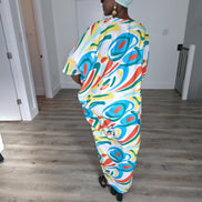 Abstract Aurora Boubou Kaftan featuring a colorful turquoise, orange, and yellow swirl pattern on white silk-satin with a mint headwrap. Back View