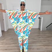 Abstract Aurora Boubou Kaftan featuring a colorful turquoise, orange, and yellow swirl pattern on white silk-satin with a mint headwrap. Spread out Full view