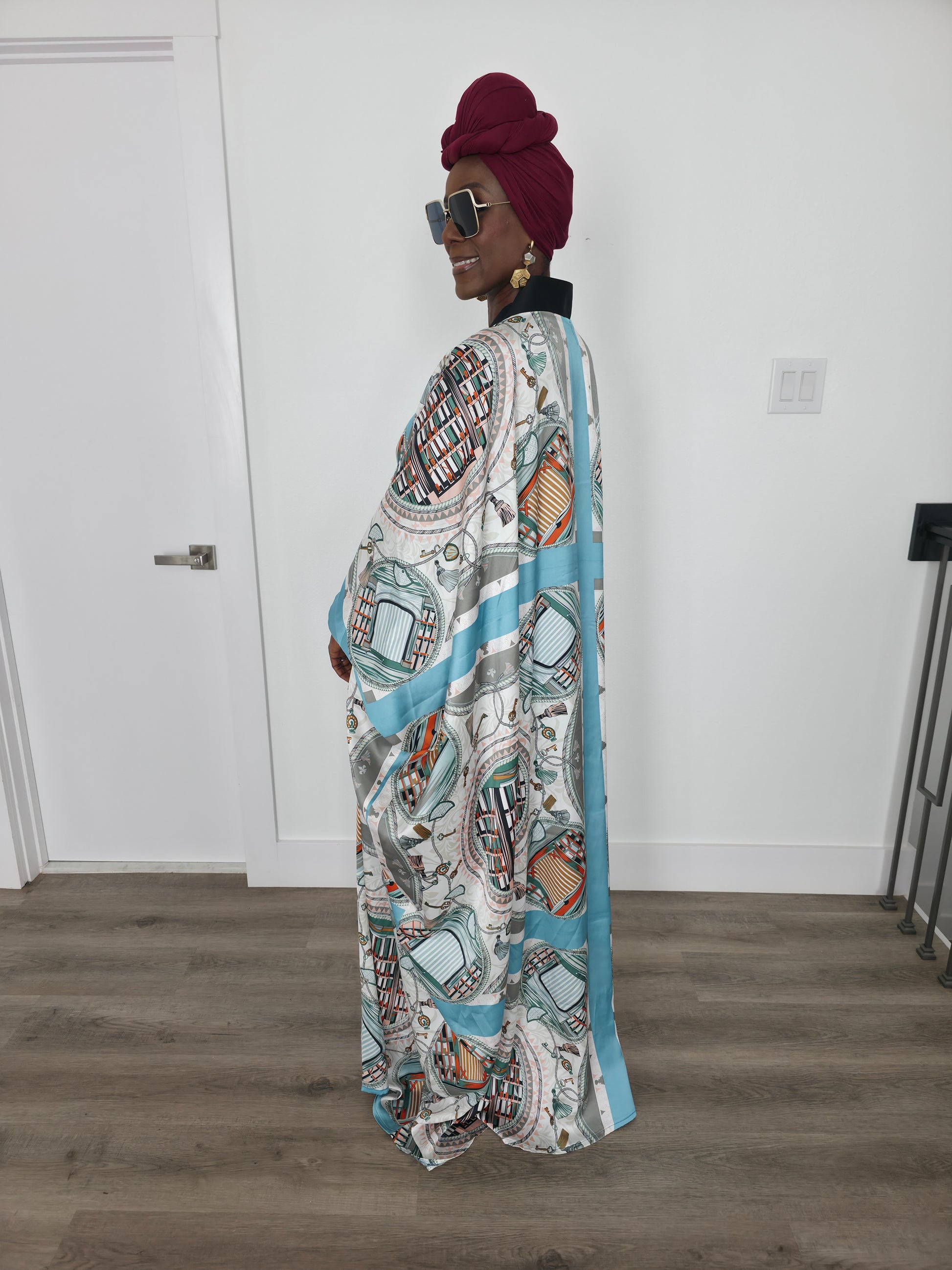 Aquatic Mosaic Boubou Kaftan featuring a teal and grey tile-patterned print with a structured black V-neck collar and flowing sleeves. Side View