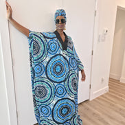Patterned Boubou Kaftan featuring a blue and turquoise concentric circular print, a solid black V-neckline, and a voluminous silhouette.