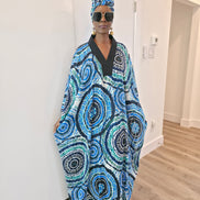 Patterned Boubou Kaftan featuring a blue and turquoise concentric circular print, a solid black V-neckline, and a voluminous silhouette.
