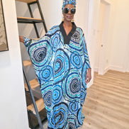 Patterned Boubou Kaftan featuring a blue and turquoise concentric circular print, a solid black V-neckline, and a voluminous silhouette.