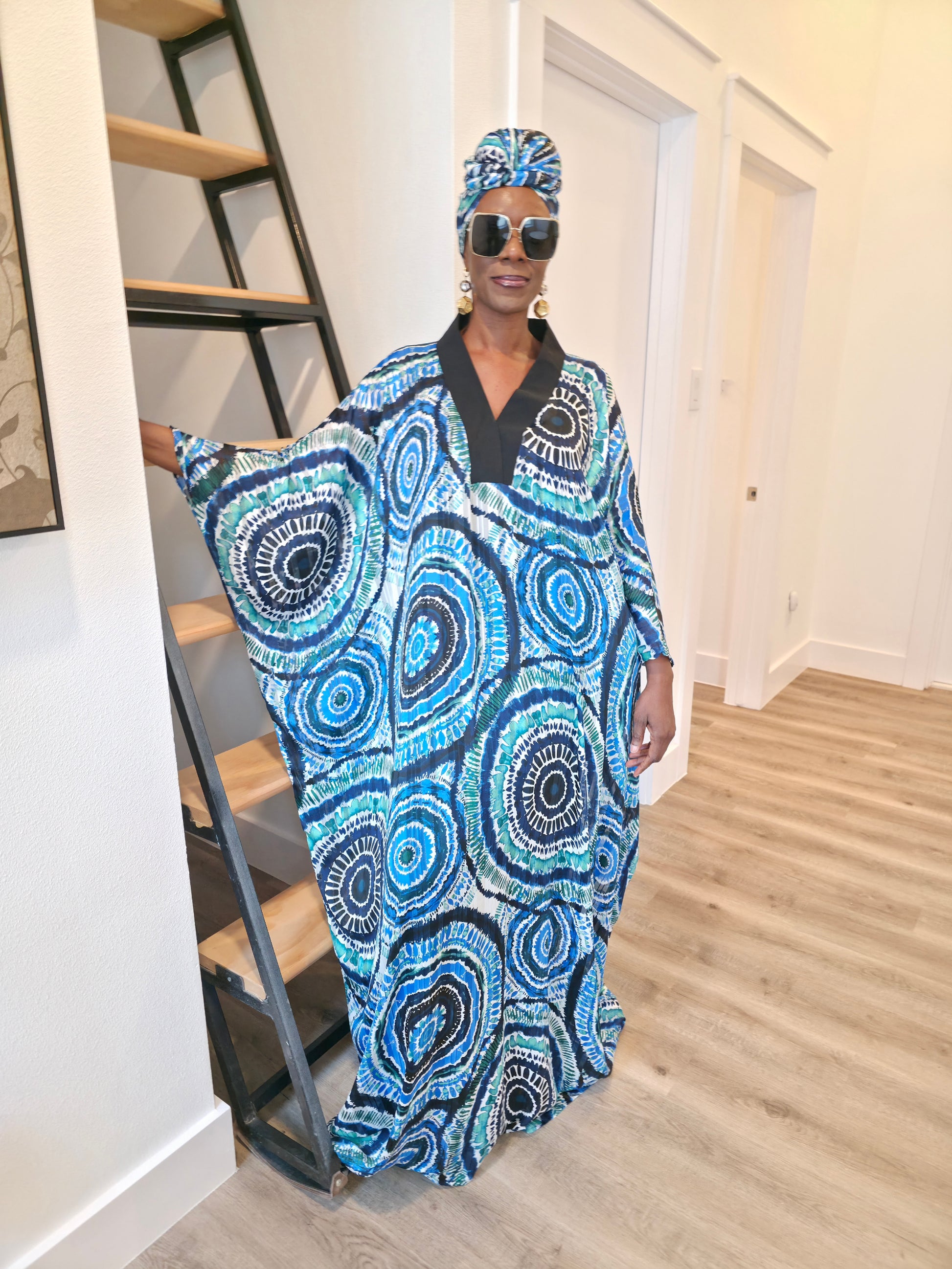 Patterned Boubou Kaftan featuring a blue and turquoise concentric circular print, a solid black V-neckline, and a voluminous silhouette.