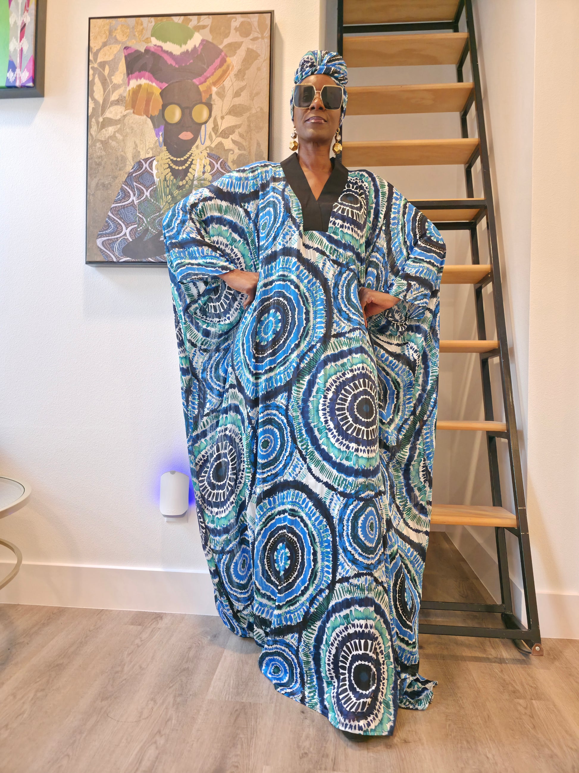 Patterned Boubou Kaftan featuring a blue and turquoise concentric circular print, a solid black V-neckline, and a voluminous silhouette.