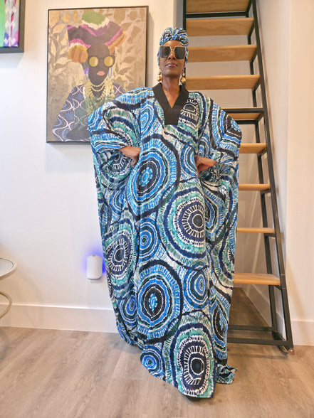 Patterned Boubou Kaftan featuring a blue and turquoise concentric circular print, a solid black V-neckline, and a voluminous silhouette.