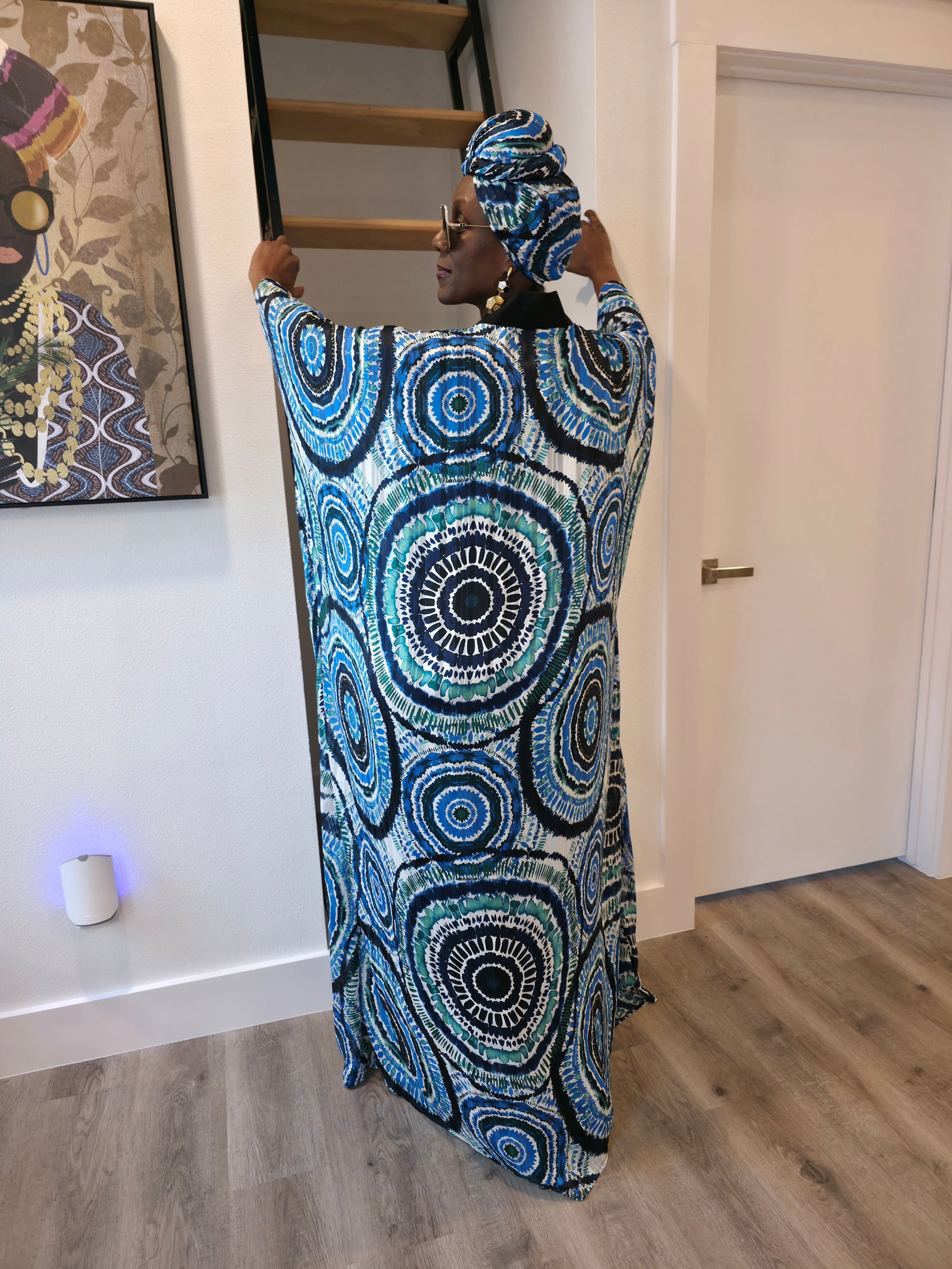 Patterned Boubou Kaftan featuring a blue and turquoise concentric circular print, a solid black V-neckline, and a voluminous silhouette.