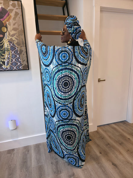Patterned Boubou Kaftan featuring a blue and turquoise concentric circular print, a solid black V-neckline, and a voluminous silhouette.