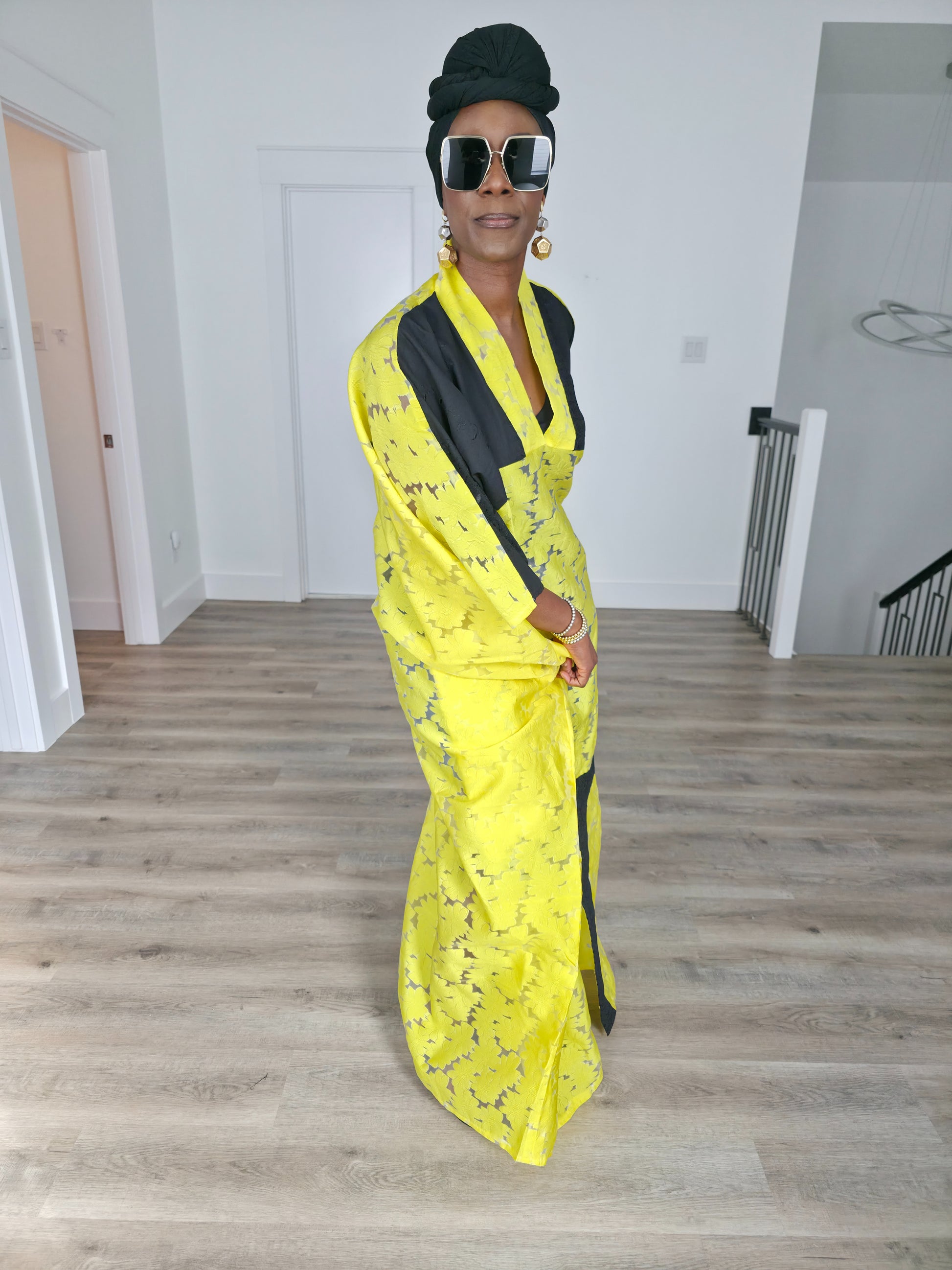 Bumblebee Boubou Kaftan in vibrant yellow textured fabric with bold black contrast panels and a matching black headwrap. Side View