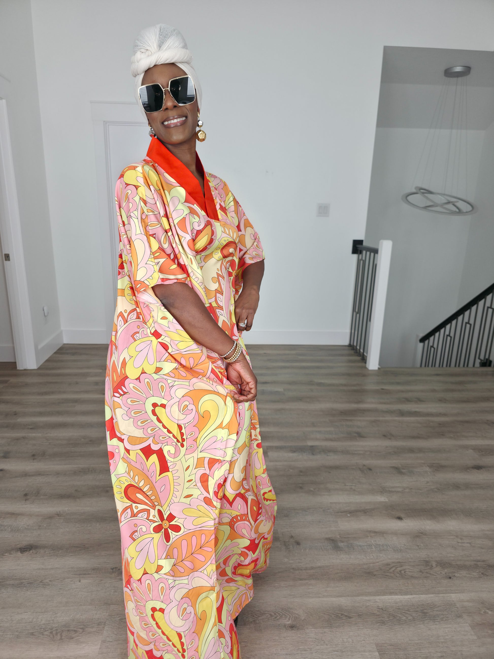Citrus Sorbet Boubou Kaftan featuring a vibrant pink, orange, and yellow organic swirl pattern with a structured orange V-neck collar. Front View