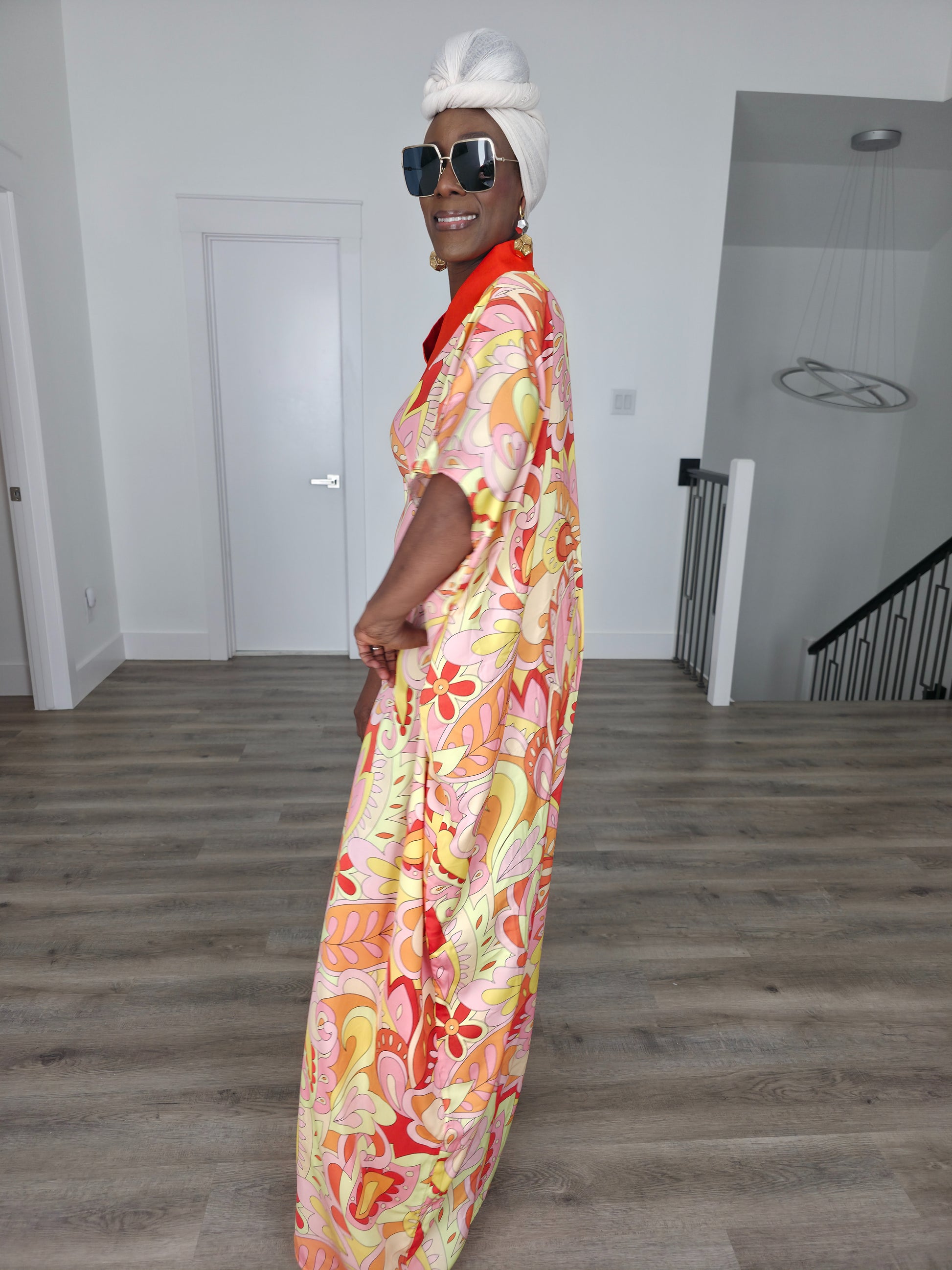 Citrus Sorbet Boubou Kaftan featuring a vibrant pink, orange, and yellow organic swirl pattern with a structured orange V-neck collar. Side Profile