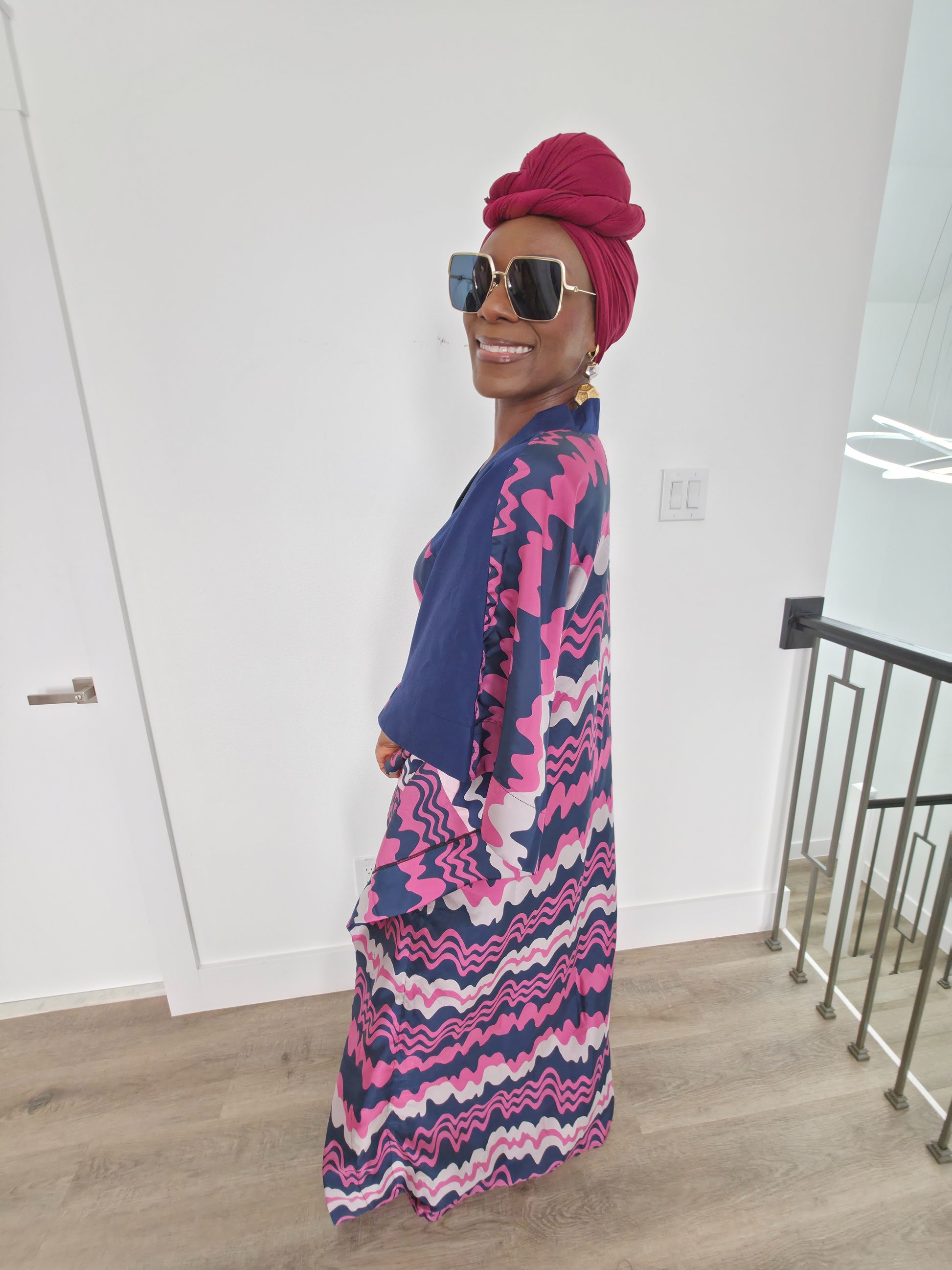 Cosmic Candy Boubou Kaftan in navy blue featuring a central horizontal panel with pink and lavender wavy patterns and a V-neck collar. Side View