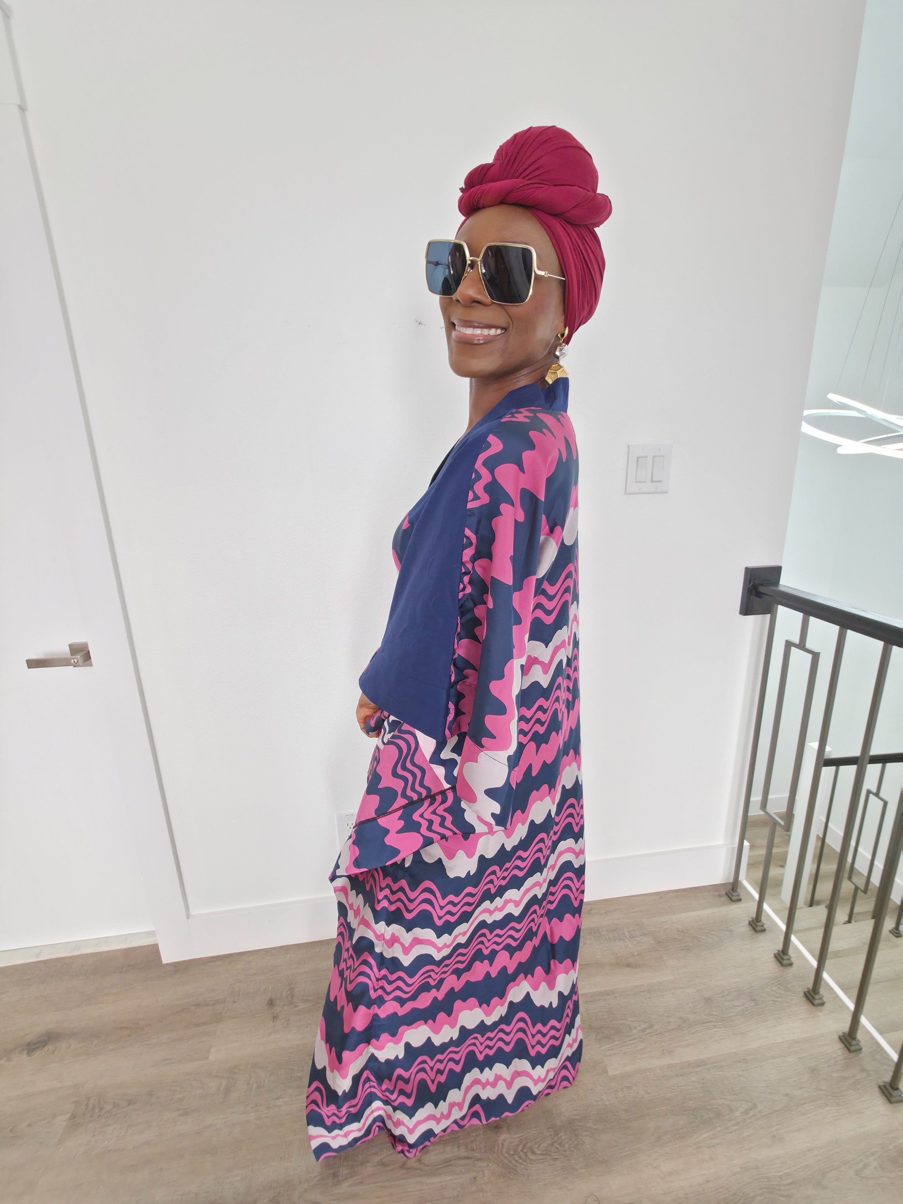 Cosmic Candy Boubou Kaftan in navy blue featuring a central horizontal panel with pink and lavender wavy patterns and a V-neck collar. Side View