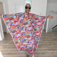Desert Wildflower Boubou Kaftan featuring a colorful abstract organic print in earth tones, blue, and pink with a mint green headwrap. Front View