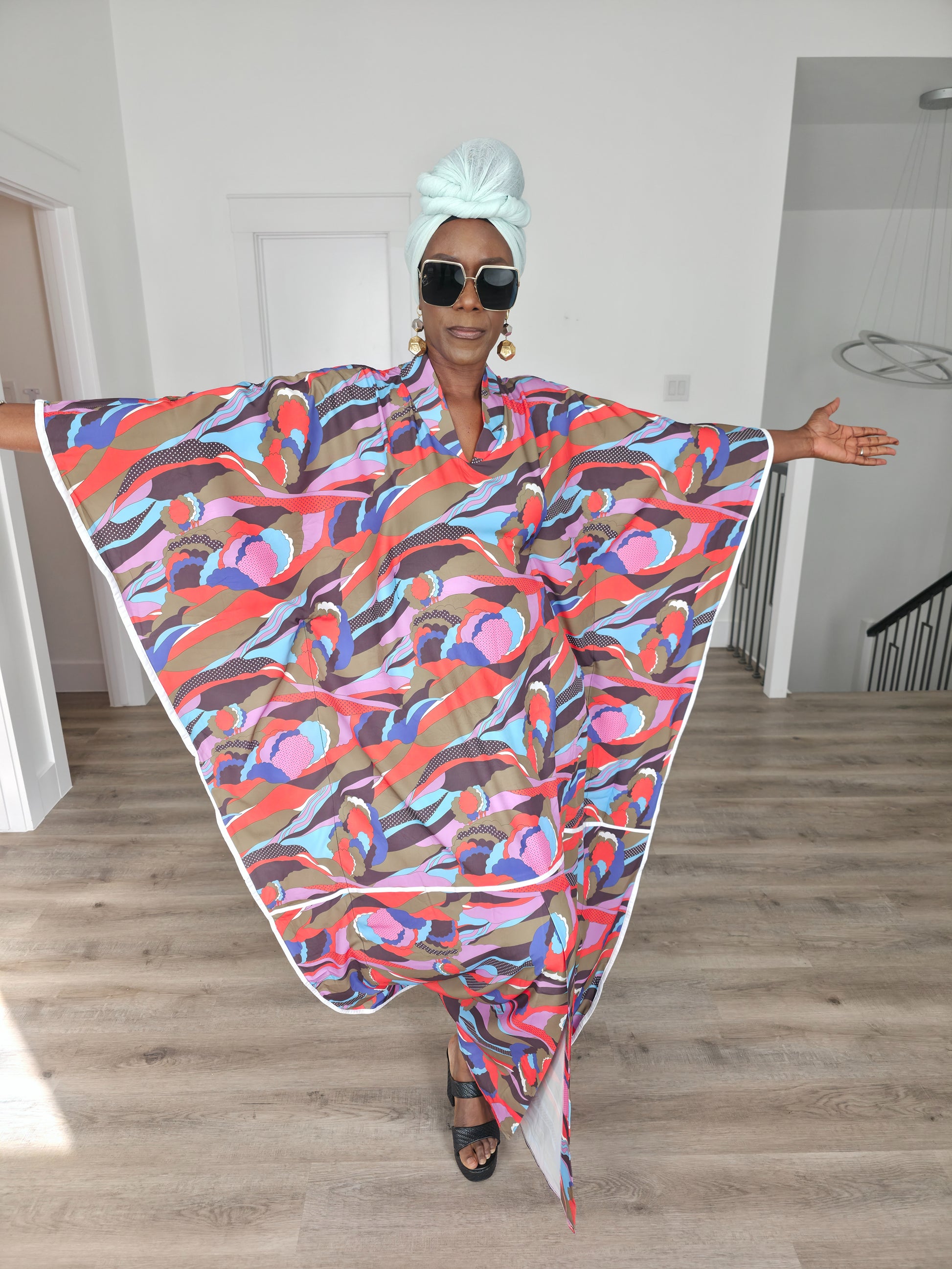 Desert Wildflower Boubou Kaftan featuring a colorful abstract organic print in earth tones, blue, and pink with a mint green headwrap. Front View