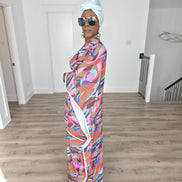 Desert Wildflower Boubou Kaftan featuring a colorful abstract organic print in earth tones, blue, and pink with a mint green headwrap. Side View