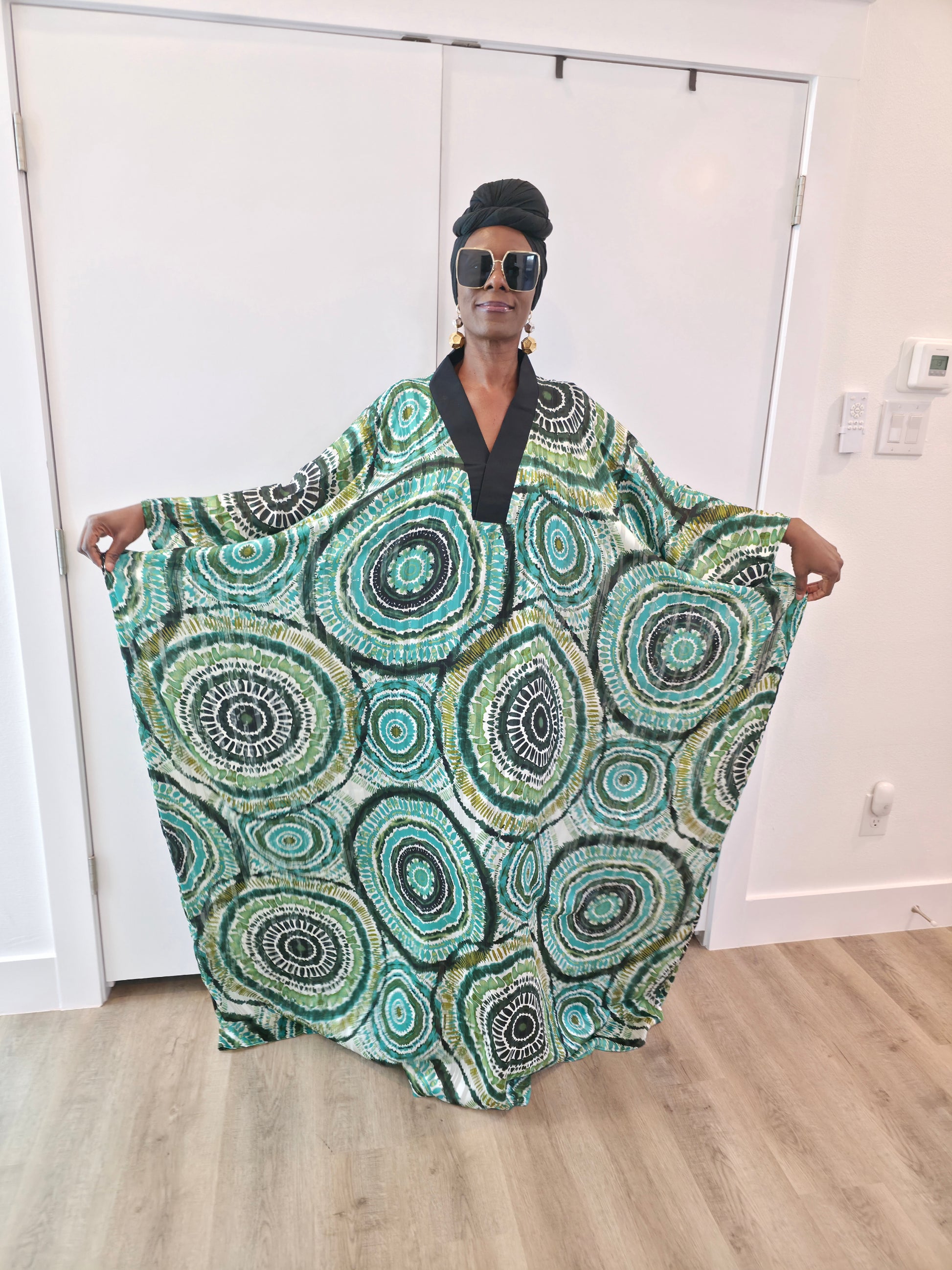 Patterned Boubou Kaftan featuring a green and black concentric circular print, a solid black V-neckline, and a wide-wing silhouette.