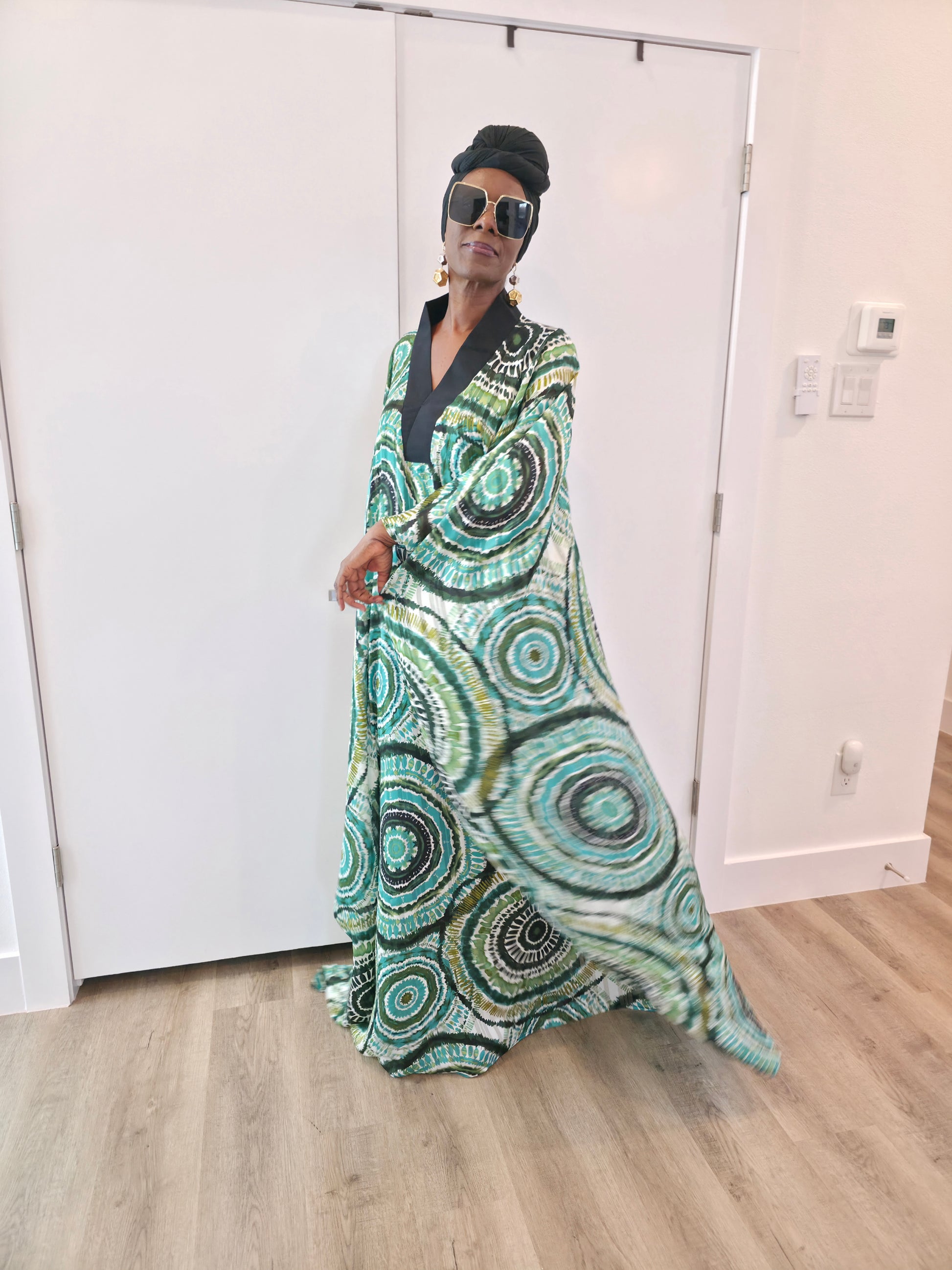 Patterned Boubou Kaftan featuring a green and black concentric circular print, a solid black V-neckline, and a wide-wing silhouette.