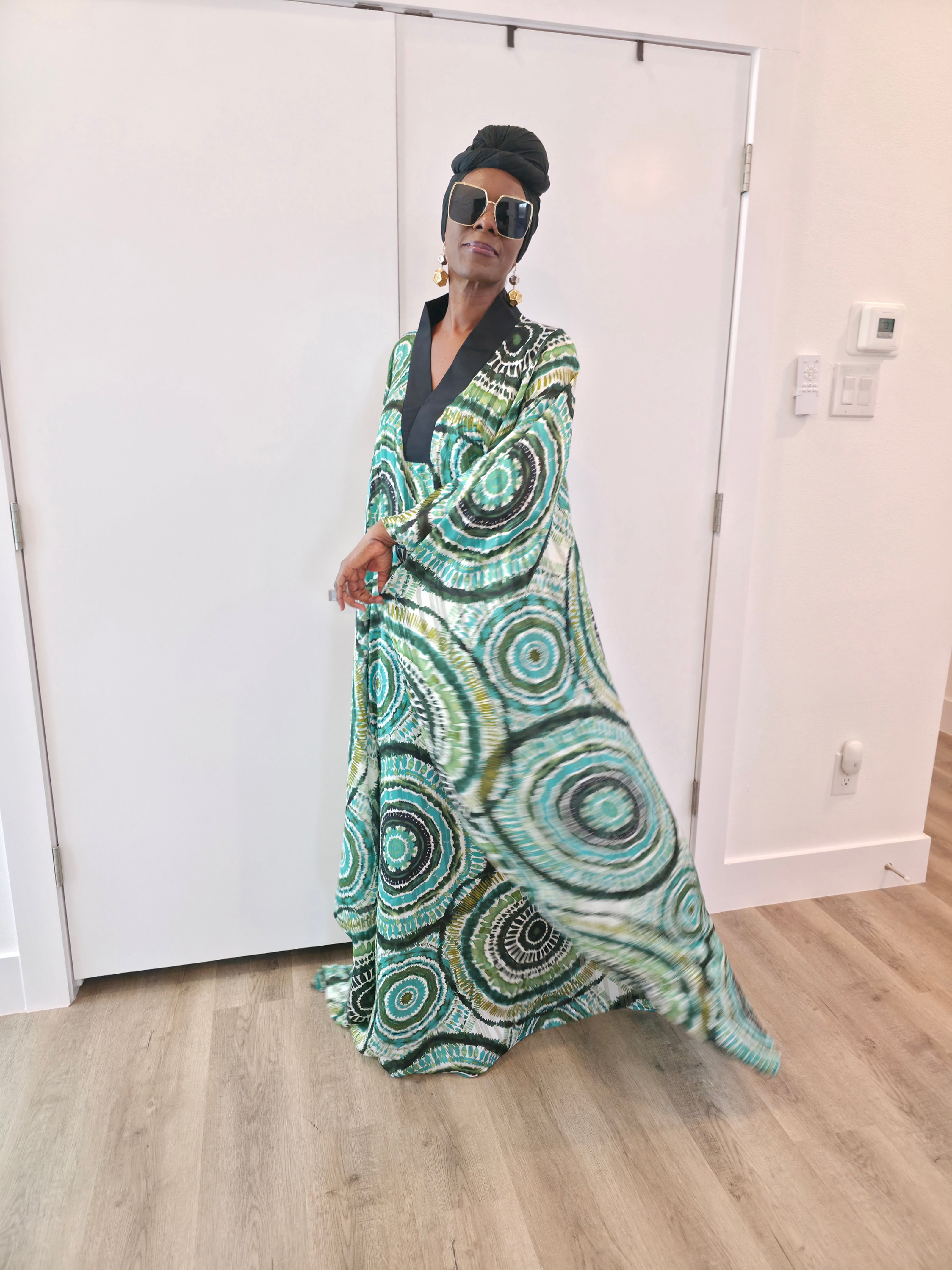 Patterned Boubou Kaftan featuring a green and black concentric circular print, a solid black V-neckline, and a wide-wing silhouette.