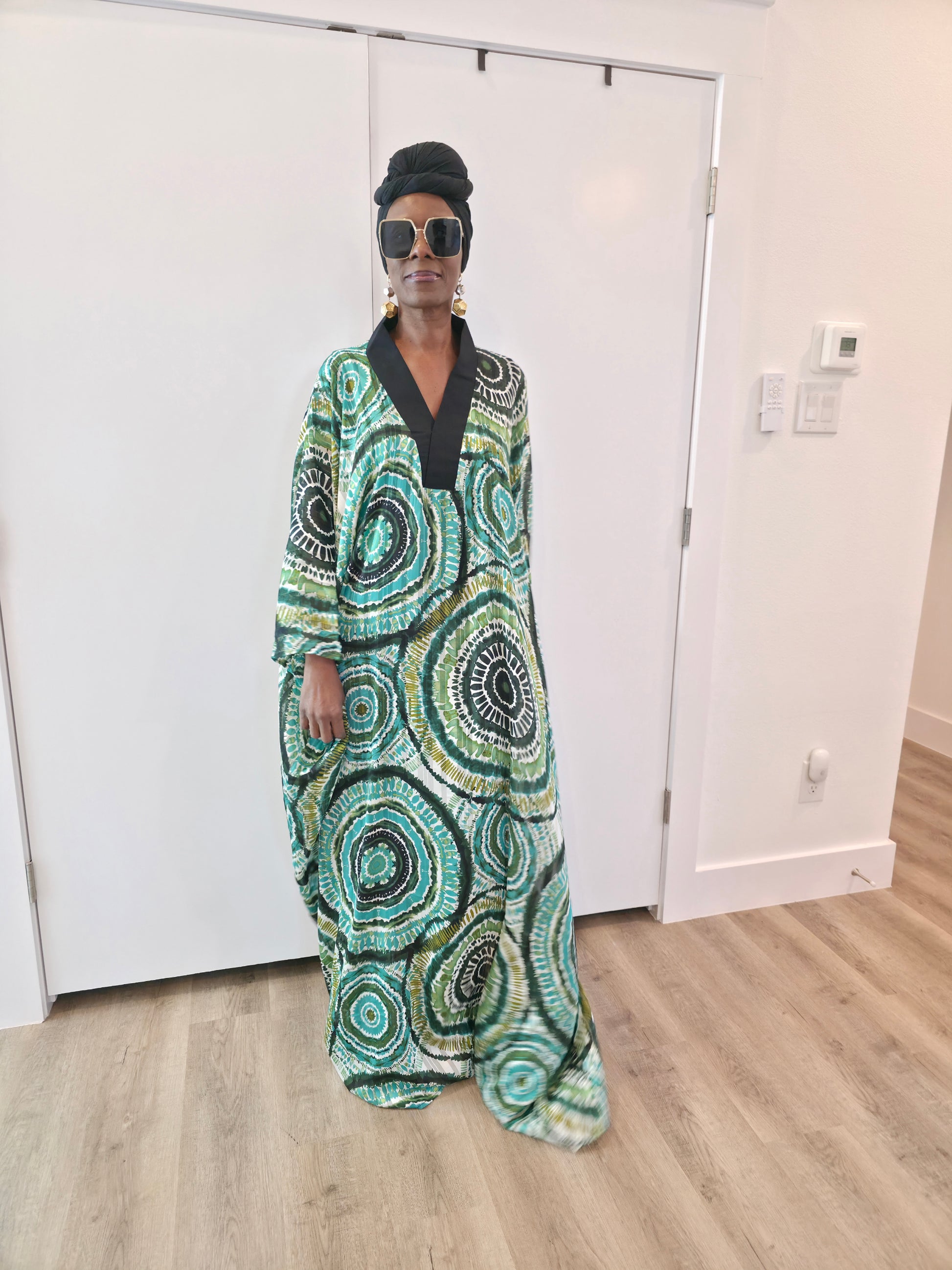 Patterned Boubou Kaftan featuring a green and black concentric circular print, a solid black V-neckline, and a wide-wing silhouette.