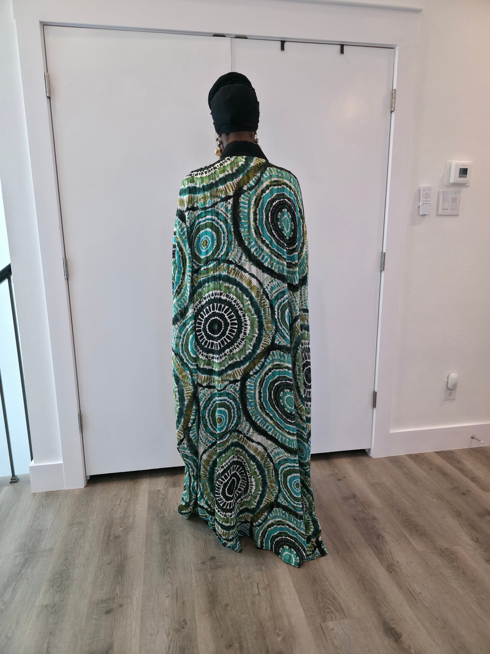 Patterned Boubou Kaftan featuring a green and black concentric circular print, a solid black V-neckline, and a wide-wing silhouette.