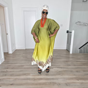 Gilded Olive Boubou Kaftan featuring an olive green and yellow gradient design with an orange V-neck collar and intricate paisley patterns along the hem.