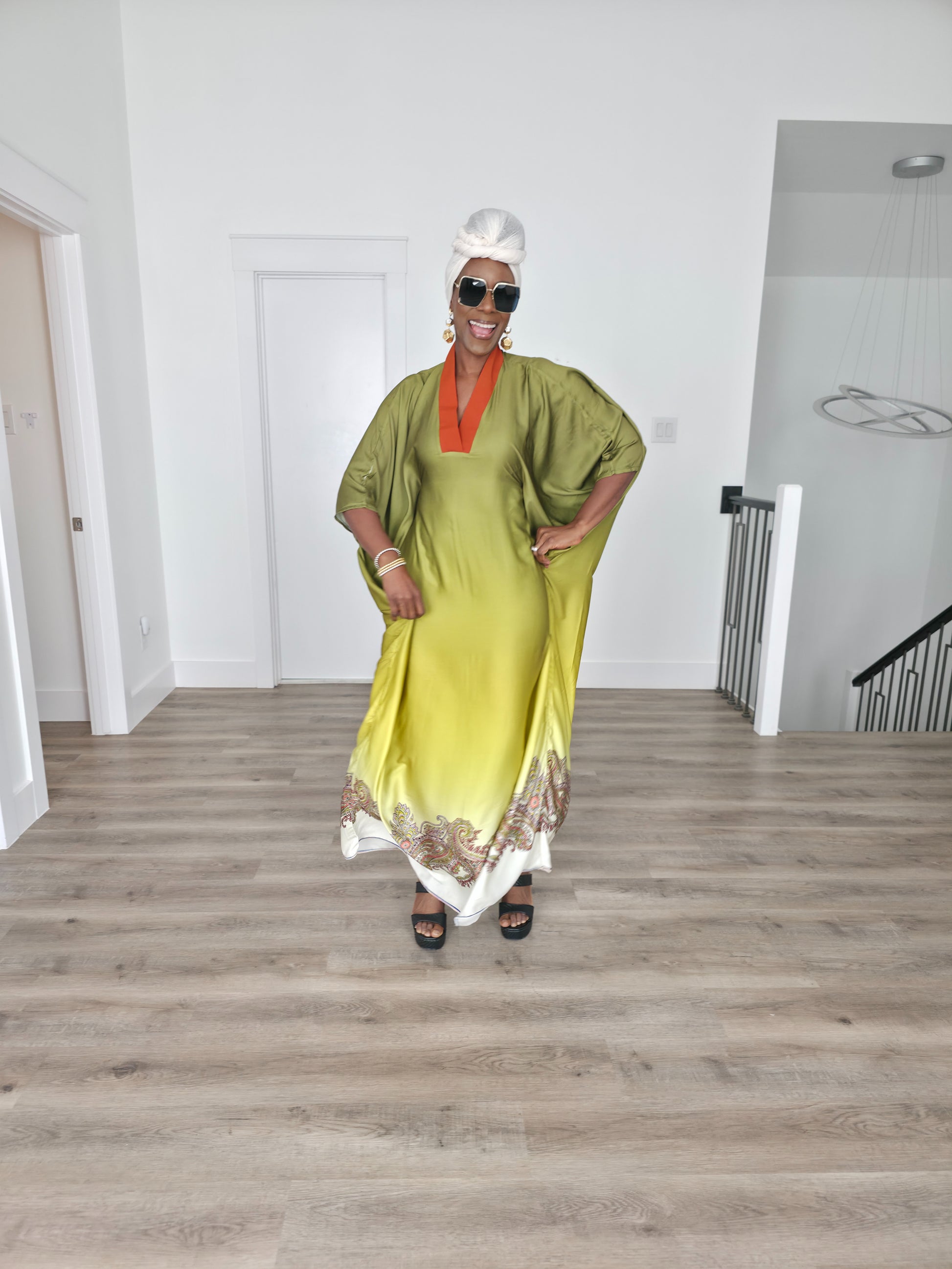 Gilded Olive Boubou Kaftan featuring an olive green and yellow gradient design with an orange V-neck collar and intricate paisley patterns along the hem.