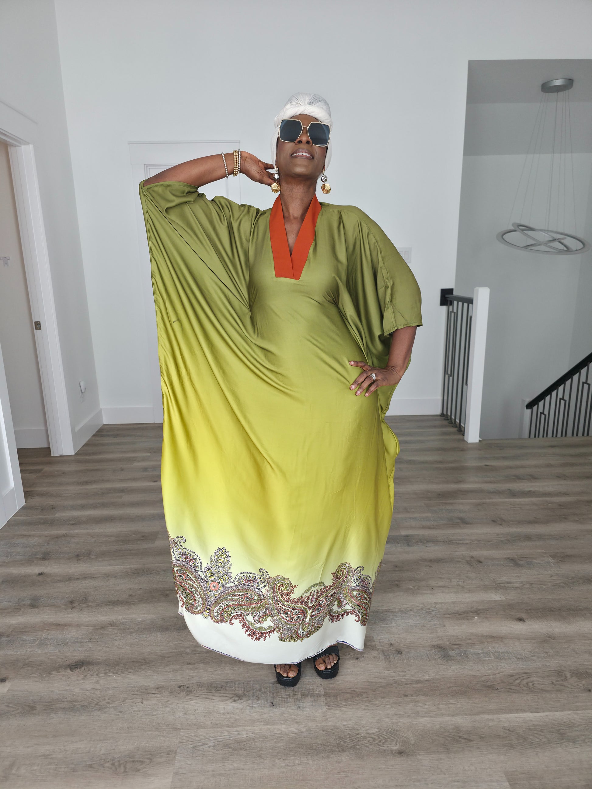 Gilded Olive Boubou Kaftan featuring an olive green and yellow gradient design with an orange V-neck collar and intricate paisley patterns along the hem. Front View